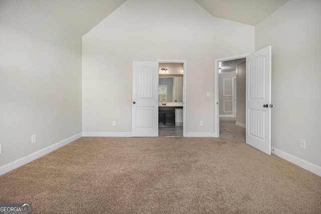 7691 Brazos Trl, Fairburn, GA 30213 - unfurnished bedroom with light colored carpet, high vaulted ceiling, and connected bathroom