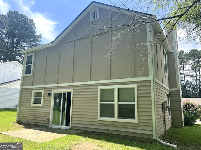 6300 Creekford Ln, Lithonia, GA 30058 - back of house with board and batten siding, a yard, and a patio
