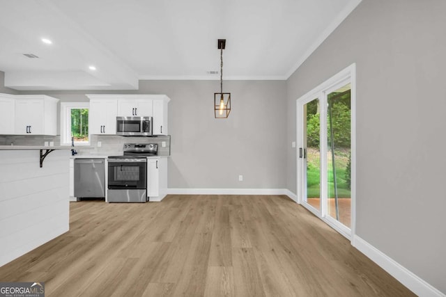 155 Carey St, Franklin Springs, GA 30662 - kitchen with stainless steel appliances, backsplash, ornamental molding, light wood-style floors, and white cabinetry