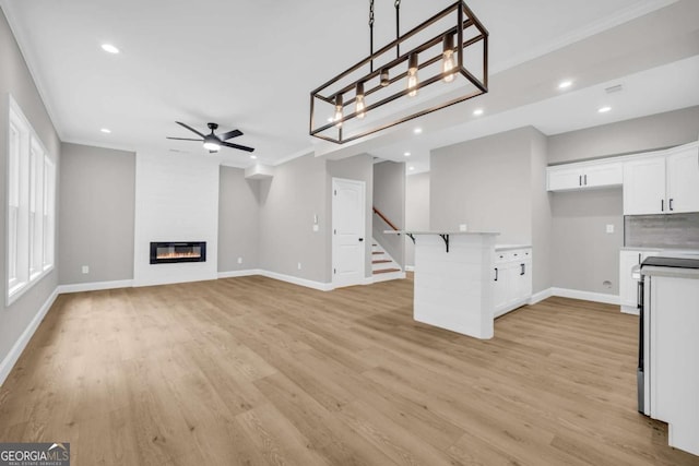155 Carey St, Franklin Springs, GA 30662 - unfurnished living room with light wood-style flooring, ceiling fan, stairs, crown molding, and recessed lighting