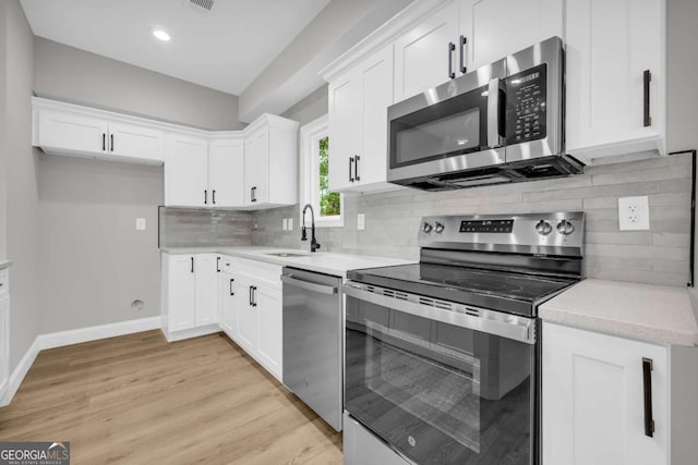 155 Carey St, Franklin Springs, GA 30662 - kitchen with stainless steel appliances, white cabinetry, light countertops, light wood finished floors, and decorative backsplash