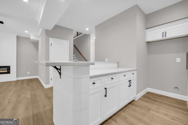 155 Carey St, Franklin Springs, GA 30662 - kitchen with light wood finished floors, white cabinetry, recessed lighting, light countertops, and heating unit
