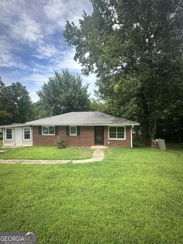 26 Fleming St, Royston, GA 30662 - ranch-style home with a front yard, a metal roof, and brick siding