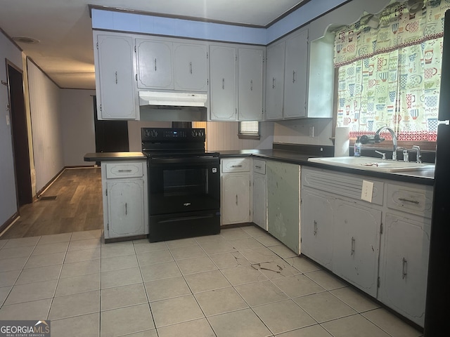 26 Fleming St, Royston, GA 30662 - kitchen featuring electric range, under cabinet range hood, light tile patterned flooring, dark countertops, and white cabinets