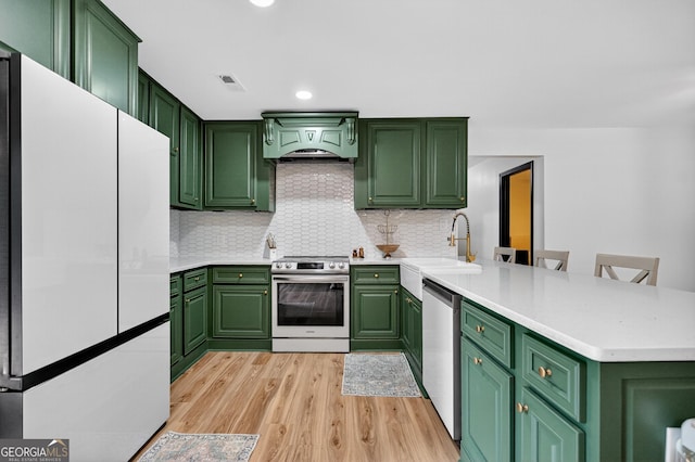 1120 Glass Bridge Rd, Lagrange, GA 30240 - kitchen featuring stainless steel appliances, a peninsula, light wood-style floors, light countertops, and decorative backsplash