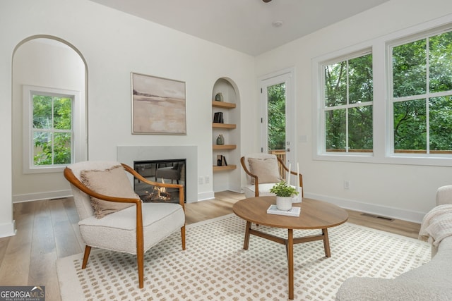 38 Mildred Pl NW, Atlanta, GA 30318 - living room with built in shelves, wood finished floors, and a glass covered fireplace