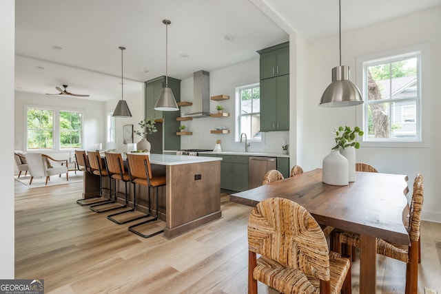 38 Mildred Pl NW, Atlanta, GA 30318 - kitchen with green cabinetry, wall chimney range hood, stainless steel dishwasher, light wood-type flooring, and healthy amount of natural light
