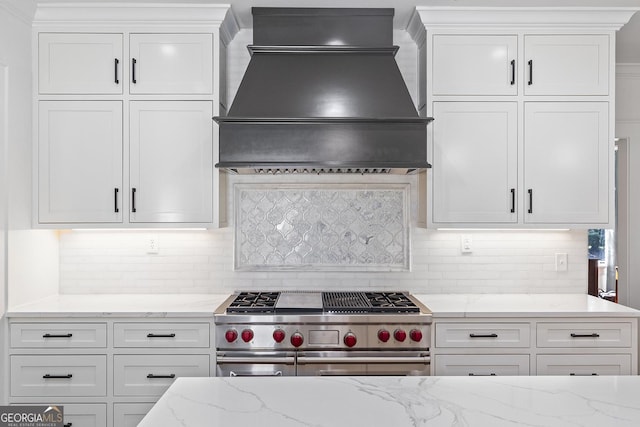 1036 Oxford Rd NE, Atlanta, GA 30306 - kitchen with custom exhaust hood, high end stove, white cabinetry, light stone countertops, and backsplash