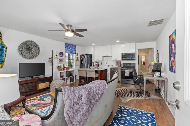 1036 Oxford Rd NE, Atlanta, GA 30306 - living room with wood finished floors, ceiling fan, a desk, and recessed lighting