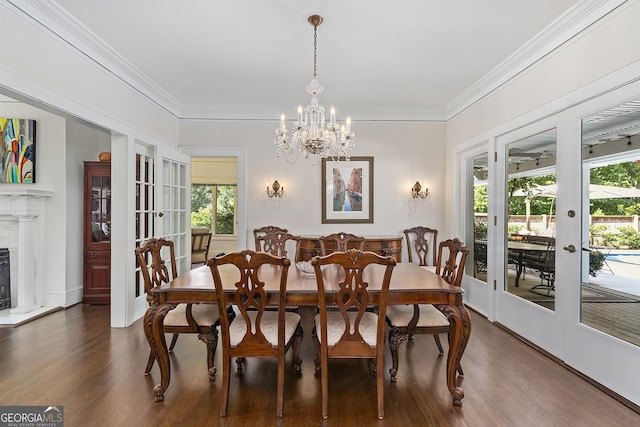 1036 Oxford Rd NE, Atlanta, GA 30306 - dining area featuring french doors, dark wood-style floors, a chandelier, ornamental molding, and a fireplace with raised hearth