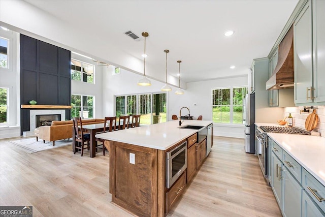 1585 Parks Rd, Forsyth, GA 31029 - kitchen featuring stainless steel appliances, recessed lighting, light wood-type flooring, an island with sink, and light countertops