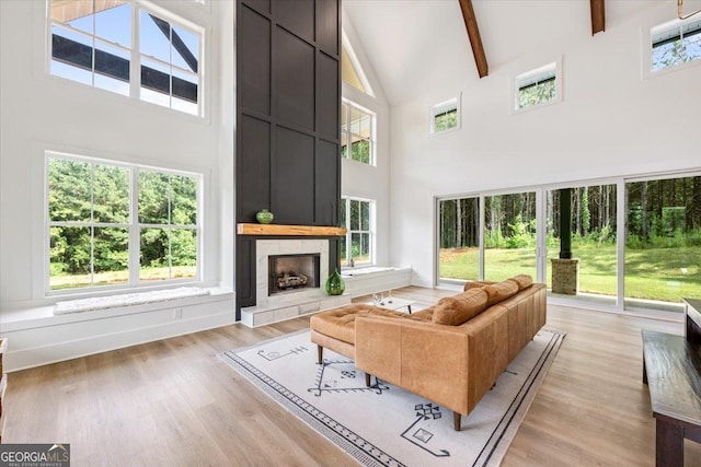 1585 Parks Rd, Forsyth, GA 31029 - living room with high vaulted ceiling, light wood-type flooring, a tile fireplace, and beam ceiling