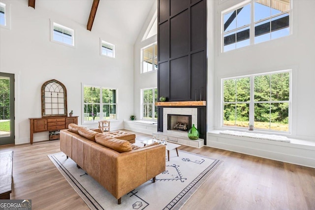 1585 Parks Rd, Forsyth, GA 31029 - living room featuring high vaulted ceiling, a tile fireplace, beam ceiling, and light wood-type flooring