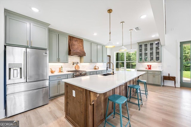 1585 Parks Rd, Forsyth, GA 31029 - kitchen featuring stainless steel appliances, premium range hood, light wood-style floors, tasteful backsplash, and gray cabinetry