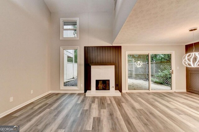 6221 Willow Run Rd, Peachtree Corners, GA 30092 - unfurnished living room with plenty of natural light, wood finished floors, and a glass covered fireplace
