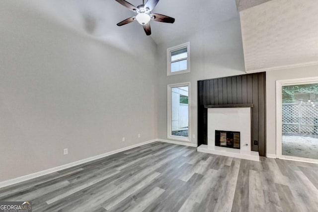 6221 Willow Run Rd, Peachtree Corners, GA 30092 - unfurnished living room featuring high vaulted ceiling, wood finished floors, ceiling fan, and a glass covered fireplace
