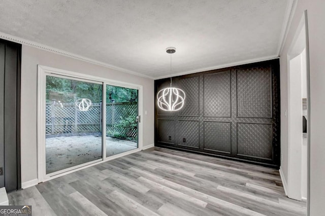 6221 Willow Run Rd, Peachtree Corners, GA 30092 - unfurnished dining area with light wood finished floors, a chandelier, ornamental molding, and a textured ceiling