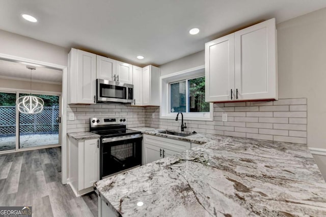 6221 Willow Run Rd, Peachtree Corners, GA 30092 - kitchen with appliances with stainless steel finishes, light stone counters, healthy amount of natural light, white cabinetry, and crown molding
