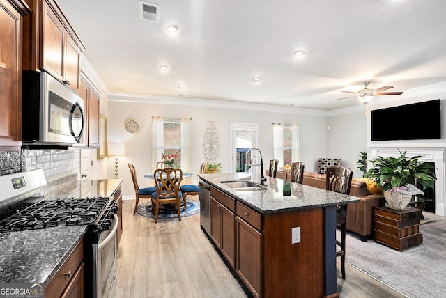 176 Malbone St SW, Cartersville, GA 30120 - kitchen featuring appliances with stainless steel finishes, a kitchen bar, light wood finished floors, backsplash, and crown molding