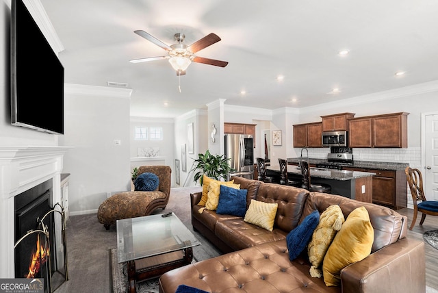 176 Malbone St SW, Cartersville, GA 30120 - living room with ceiling fan, a warm lit fireplace, crown molding, and recessed lighting