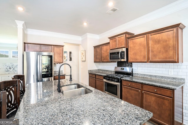 176 Malbone St SW, Cartersville, GA 30120 - kitchen with appliances with stainless steel finishes, crown molding, dark stone countertops, backsplash, and a center island with sink