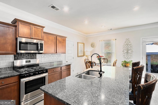 176 Malbone St SW, Cartersville, GA 30120 - kitchen featuring stainless steel appliances, a kitchen island with sink, plenty of natural light, a kitchen bar, and ornamental molding