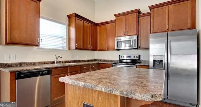 176 Calm Oaks Cir, Savannah, GA 31419 - kitchen featuring stainless steel appliances, a center island, brown cabinets, and dark countertops