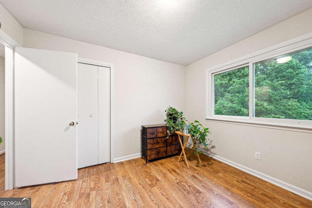 155 Windy Hill Ct, Alpharetta, GA 30004 - bedroom with light wood-style flooring, a textured ceiling, and a closet