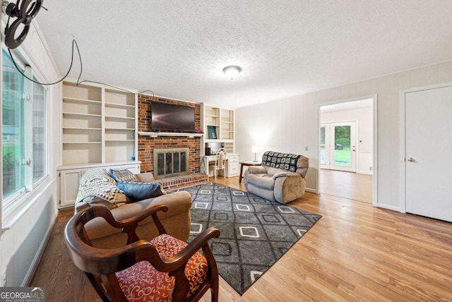 155 Windy Hill Ct, Alpharetta, GA 30004 - living room featuring wood finished floors, a brick fireplace, a textured ceiling, and built in shelves