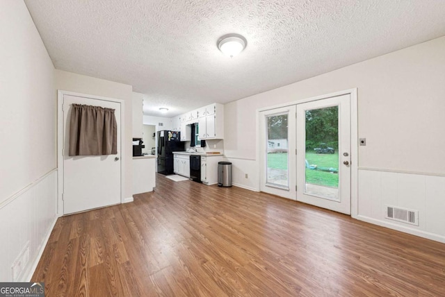 155 Windy Hill Ct, Alpharetta, GA 30004 - unfurnished living room featuring a textured ceiling, wood finished floors, and a wainscoted wall