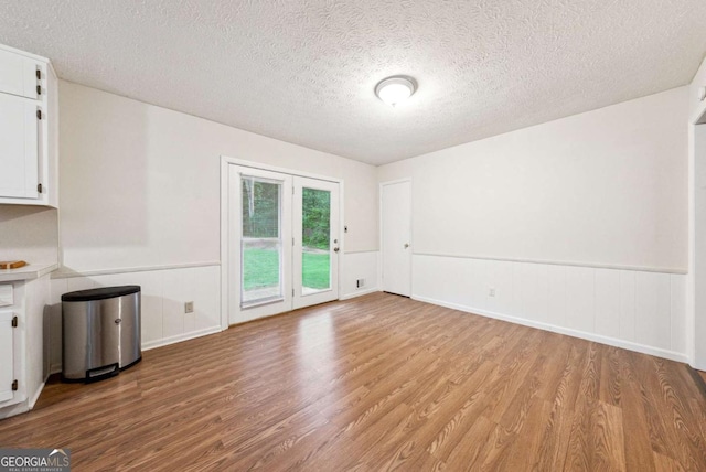 155 Windy Hill Ct, Alpharetta, GA 30004 - unfurnished dining area with wood finished floors, a textured ceiling, and a wainscoted wall