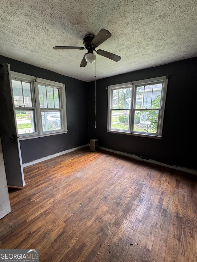 8373 Chicago Ave, Douglasville, GA 30134 - empty room featuring wood finished floors, ceiling fan, a textured ceiling, and plenty of natural light