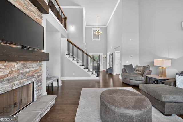 2112 Meadowood Cv, Monroe, GA 30655 - living room featuring stairway, a towering ceiling, crown molding, wood finished floors, and a chandelier