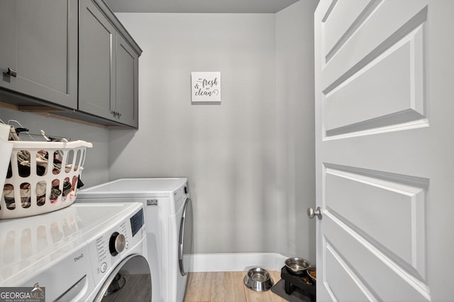2112 Meadowood Cv, Monroe, GA 30655 - laundry room with washer and dryer, cabinet space, and light wood finished floors