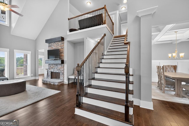 2112 Meadowood Cv, Monroe, GA 30655 - staircase with high vaulted ceiling, a fireplace, a chandelier, hardwood / wood-style flooring, and ceiling fan