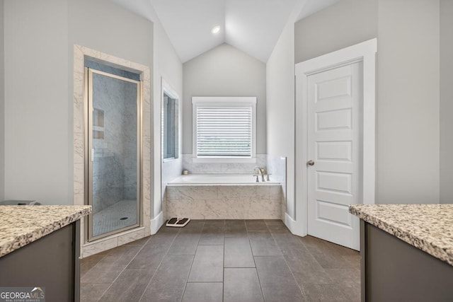 2112 Meadowood Cv, Monroe, GA 30655 - bathroom with vanity, a bath, a stall shower, vaulted ceiling, and tile patterned floors