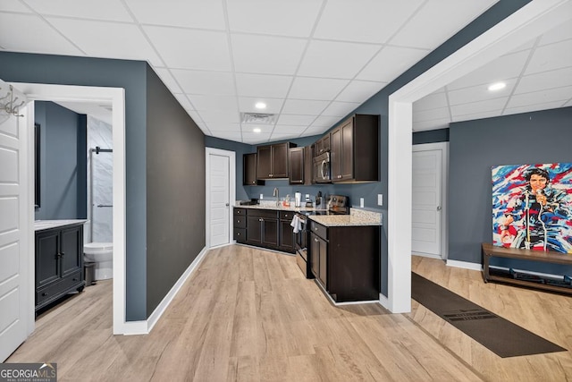 2112 Meadowood Cv, Monroe, GA 30655 - kitchen featuring electric range oven, a drop ceiling, stainless steel microwave, light wood-style flooring, and dark brown cabinets
