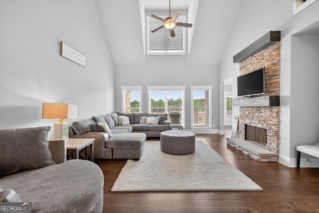 2112 Meadowood Cv, Monroe, GA 30655 - living room with high vaulted ceiling, a stone fireplace, a ceiling fan, and dark wood-style floors