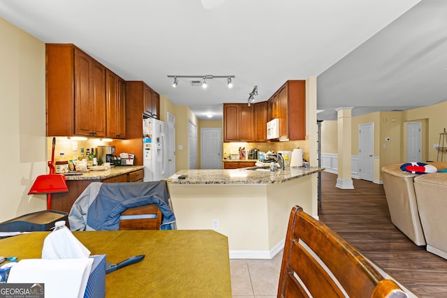 10 Links Ct, Newnan, GA 30265 - kitchen featuring white appliances, tasteful backsplash, open floor plan, ornate columns, and light stone countertops