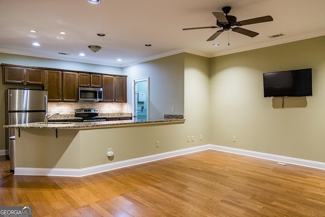 105 Maplecrest Ln SE, Rome, GA 30161 - kitchen with stainless steel appliances, light wood-type flooring, light stone counters, recessed lighting, and tasteful backsplash