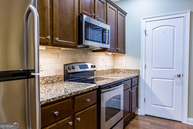 105 Maplecrest Ln SE, Rome, GA 30161 - kitchen with appliances with stainless steel finishes, dark brown cabinetry, decorative backsplash, dark wood finished floors, and light stone countertops