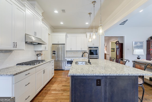 1911 Bent Pine Park, Statham, GA 30666 - kitchen featuring appliances with stainless steel finishes, under cabinet range hood, ornamental molding, a breakfast bar, and white cabinetry