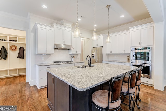 1911 Bent Pine Park, Statham, GA 30666 - kitchen with stainless steel appliances, under cabinet range hood, ornamental molding, an island with sink, and white cabinets