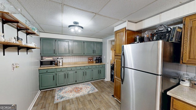 15 Aragon Rd, Aragon, GA 30104 - kitchen with stainless steel appliances, green cabinetry, light wood finished floors, light countertops, and a paneled ceiling
