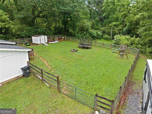 154 Fairview Rd, Ball Ground, GA 30107 - fenced backyard featuring a trampoline and a storage unit