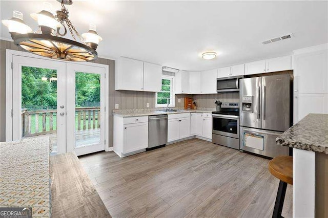 154 Fairview Rd, Ball Ground, GA 30107 - kitchen with appliances with stainless steel finishes, a chandelier, light wood-style floors, and white cabinetry