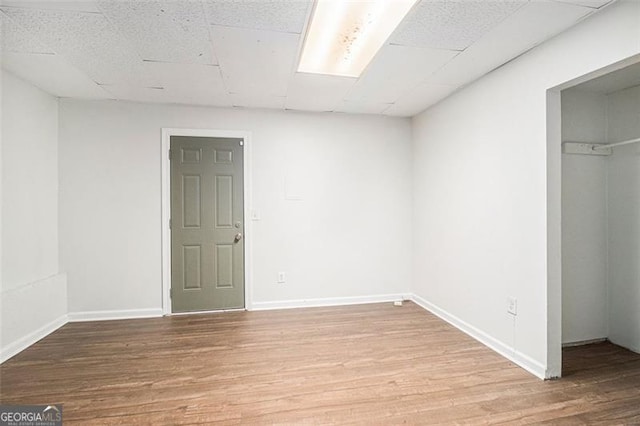 3440 Oaktree, Stonecrest, GA 30038 - unfurnished bedroom with a walk in closet, wood finished floors, a paneled ceiling, and a closet