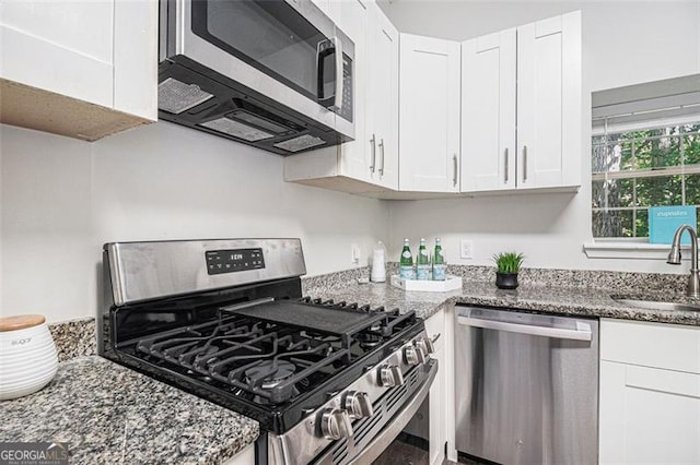 3440 Oaktree, Stonecrest, GA 30038 - kitchen featuring appliances with stainless steel finishes, dark stone countertops, and white cabinetry