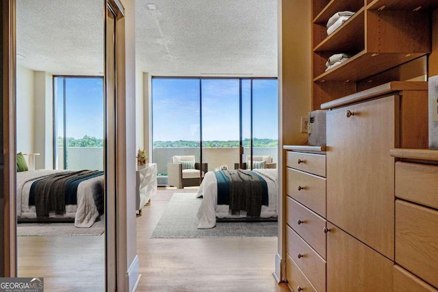 2575 Peachtree Rd NE Unit 15G, Atlanta, GA 30305 - bedroom with a wall of windows, wood finished floors, and a textured ceiling
