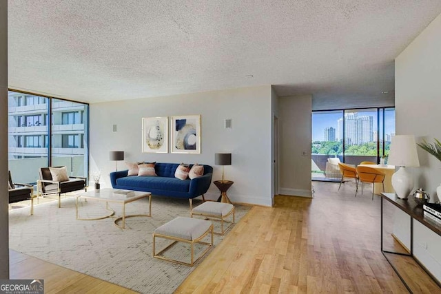 2575 Peachtree Rd NE Unit 15G, Atlanta, GA 30305 - living room with a textured ceiling, wood finished floors, and a wall of windows